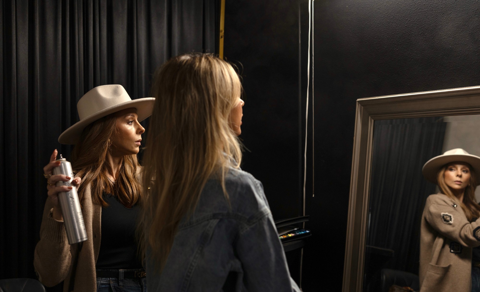 Kim Brannon styling Jordan's hair backstage at the brand shoot, both reflected in a mirror